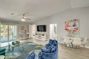 A spacious living room with a large TV, a dining area, and a view of the outdoors. - Canal-front Gem! 7 Mi to Port Charlotte Beach Park (Port Charlotte)