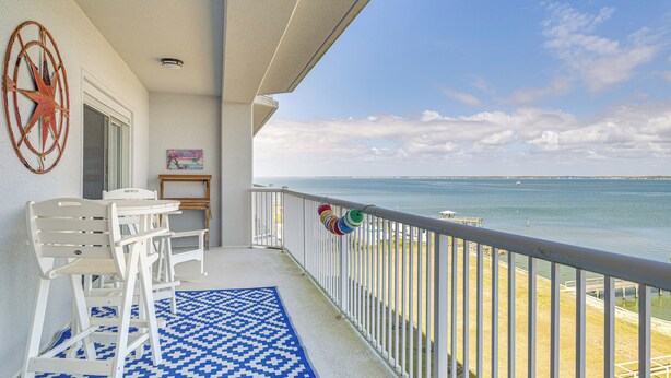 A balcony with a view of the sea, white chairs, a patterned rug, and a star decoration on the wall. - Walk to Ocean! Atlantic Beach Condo w/ Pool Access (Atlantic Beach)