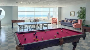 A pool table, a sofa, and a view of the ocean. - Walk to Ocean! Atlantic Beach Condo w/ Pool Access (Atlantic Beach)