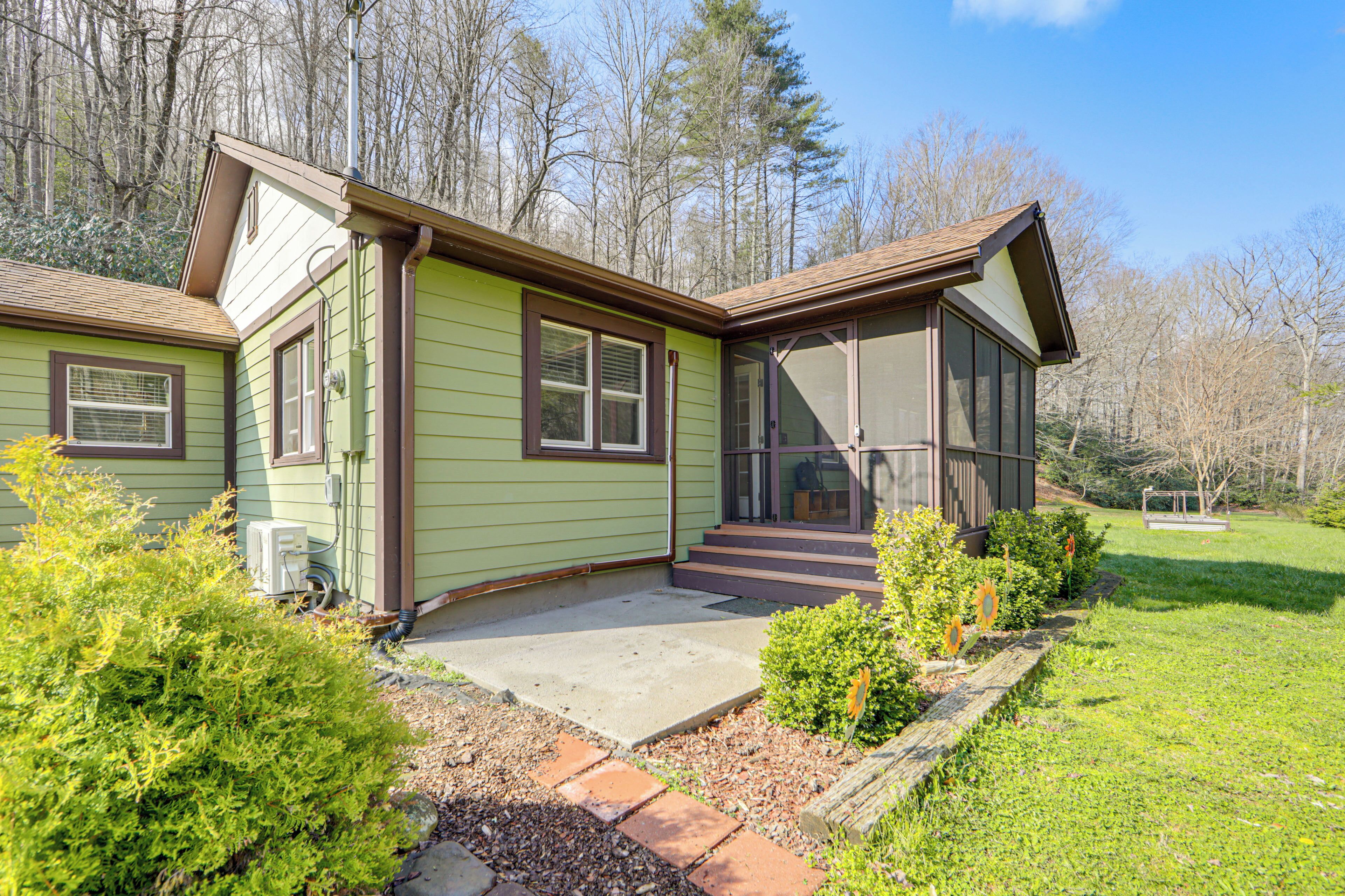 A two-story house with a covered porch, a front yard with a wooden fence, and a driveway leading to the entrance.