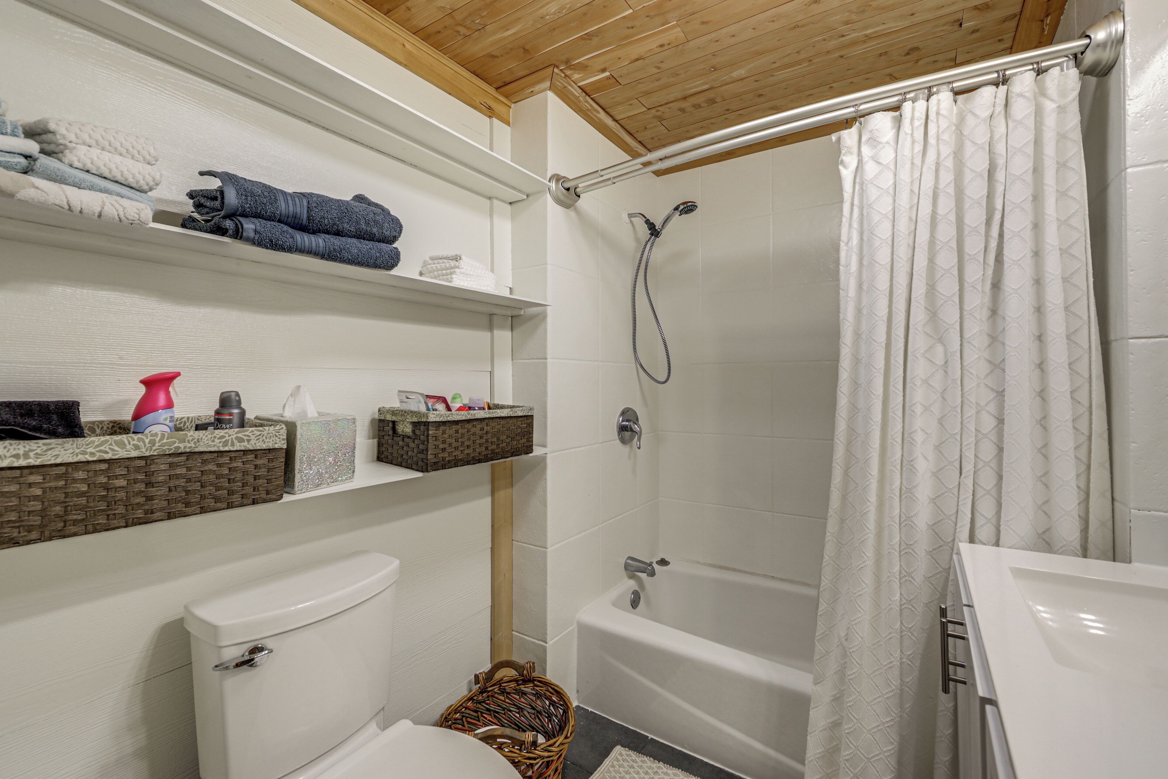 Ein Badezimmer mit Toilette, Waschbecken, Badewanne und Duschvorhang.