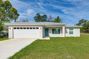 A single-story house with a garage, a front door, and a small porch. - Dunnellon Escape w/ Yard: 8 Mi to Rainbow River (Dunnellon)