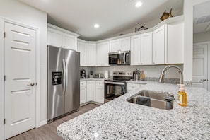A kitchen with white cabinets, stainless steel appliances, a granite countertop, and a sink. - Dunnellon Escape w/ Yard: 8 Mi to Rainbow River (Dunnellon)