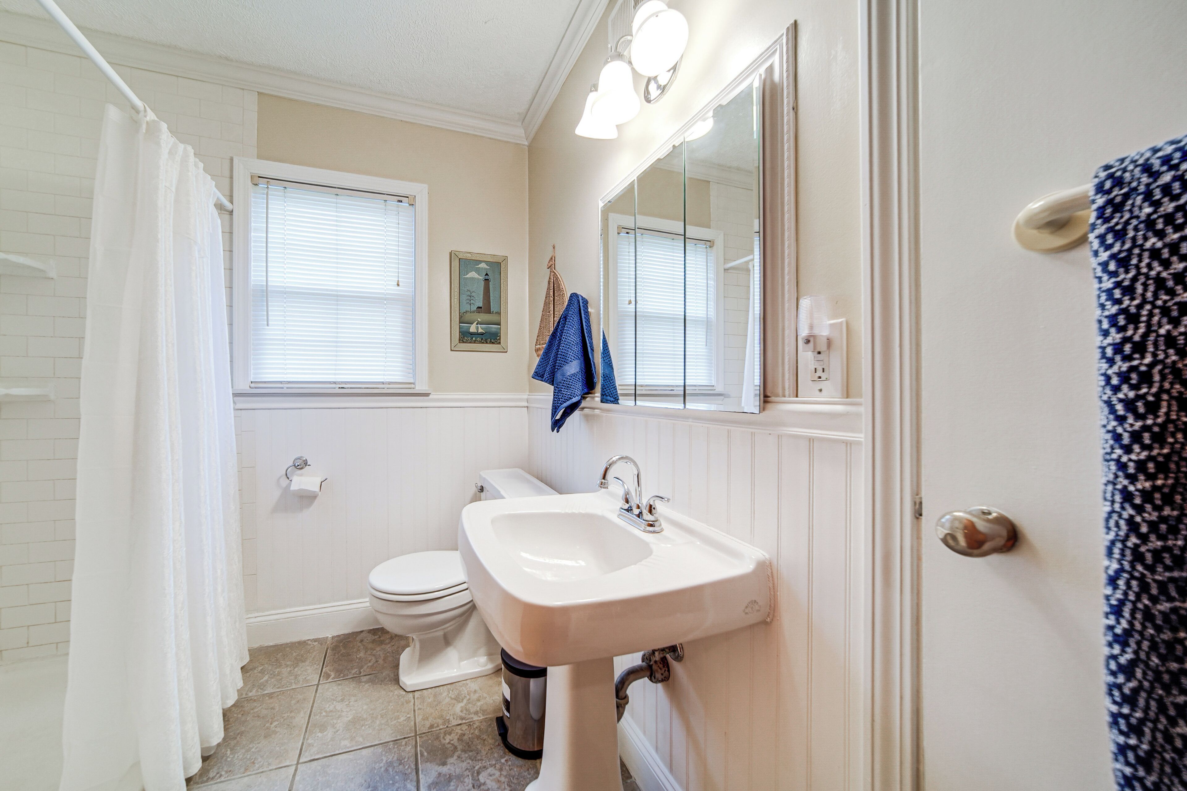 A bathroom with a toilet, sink, and shower curtain.
