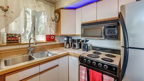 Une cuisine équipée d’un évier, d’une cuisinière, d’un four à micro-ondes et d’un réfrigérateur.