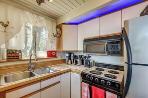 A kitchen with a sink, stove, microwave, and refrigerator. - Running Springs Retreat: Ski, Hike & Relax! (Running Springs)