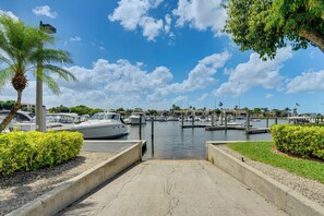 A marina with boats docked, a clear sky, and a palm tree. - Resort-style Fort Myers Gem: Swim, Golf & Cruise! (Fort Myers)