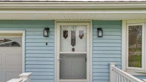 Een huis met een voordeur, een garage en een trap naar de veranda.