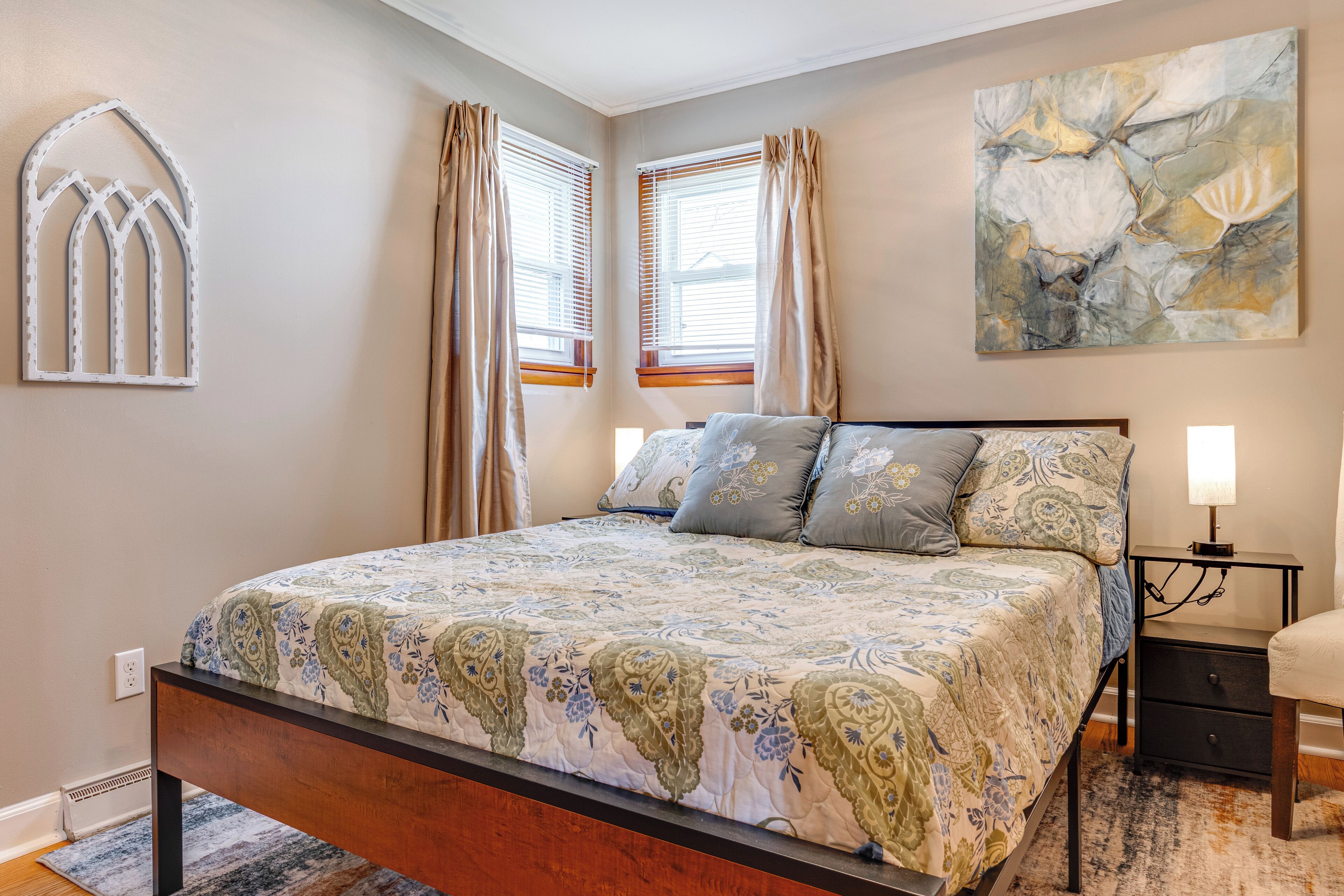 Un dormitorio con cama, mesita de noche y decoración en la pared.
