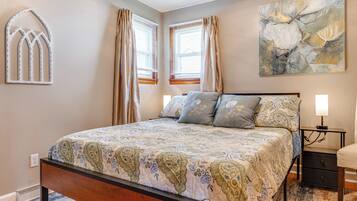 Un dormitorio con cama, mesita de noche y decoración en la pared.