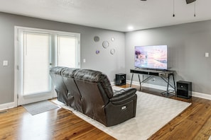 A living room with a reclining chair, a television, and speakers.