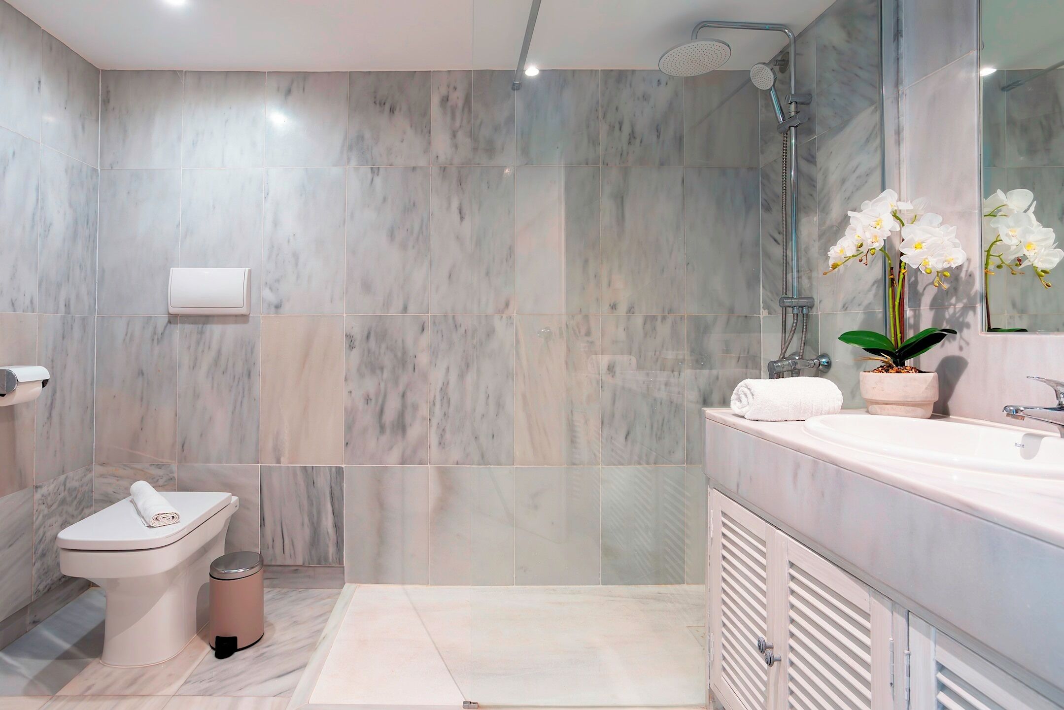 Une salle de bain moderne équipée de toilettes, d’un bidet, d’une douche et d’un lavabo.