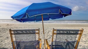 Two beach chairs with a blue umbrella in the background. - Sunset Rentals | Ocean Dunes 121 (Hilton Head Island)