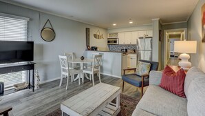 A compact living space with a dining area, kitchenette, and seating area. - Sunset Rentals | Ocean Dunes 121 (Hilton Head Island)