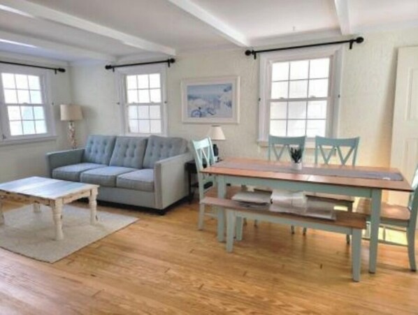 Una habitación con un sofá, una mesa y sillas.