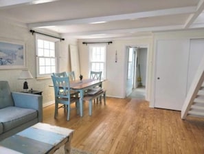 Una habitación con una mesa de comedor, sillas, un sofá y una lámpara.