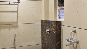 Une salle de bain avec douche, toilettes et lavabo.