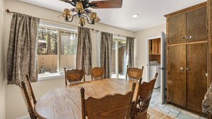 Comedor con mesa y sillas de madera, una araña y un aparador grande de madera.