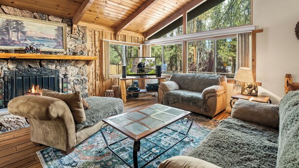 Una sala de estar acogedora con chimenea, ventanas amplias y asientos cómodos.