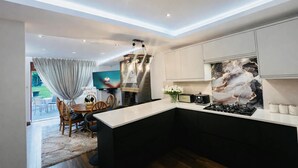 Cocina moderna con comedor, televisión y protector de salpicadero de piedra.