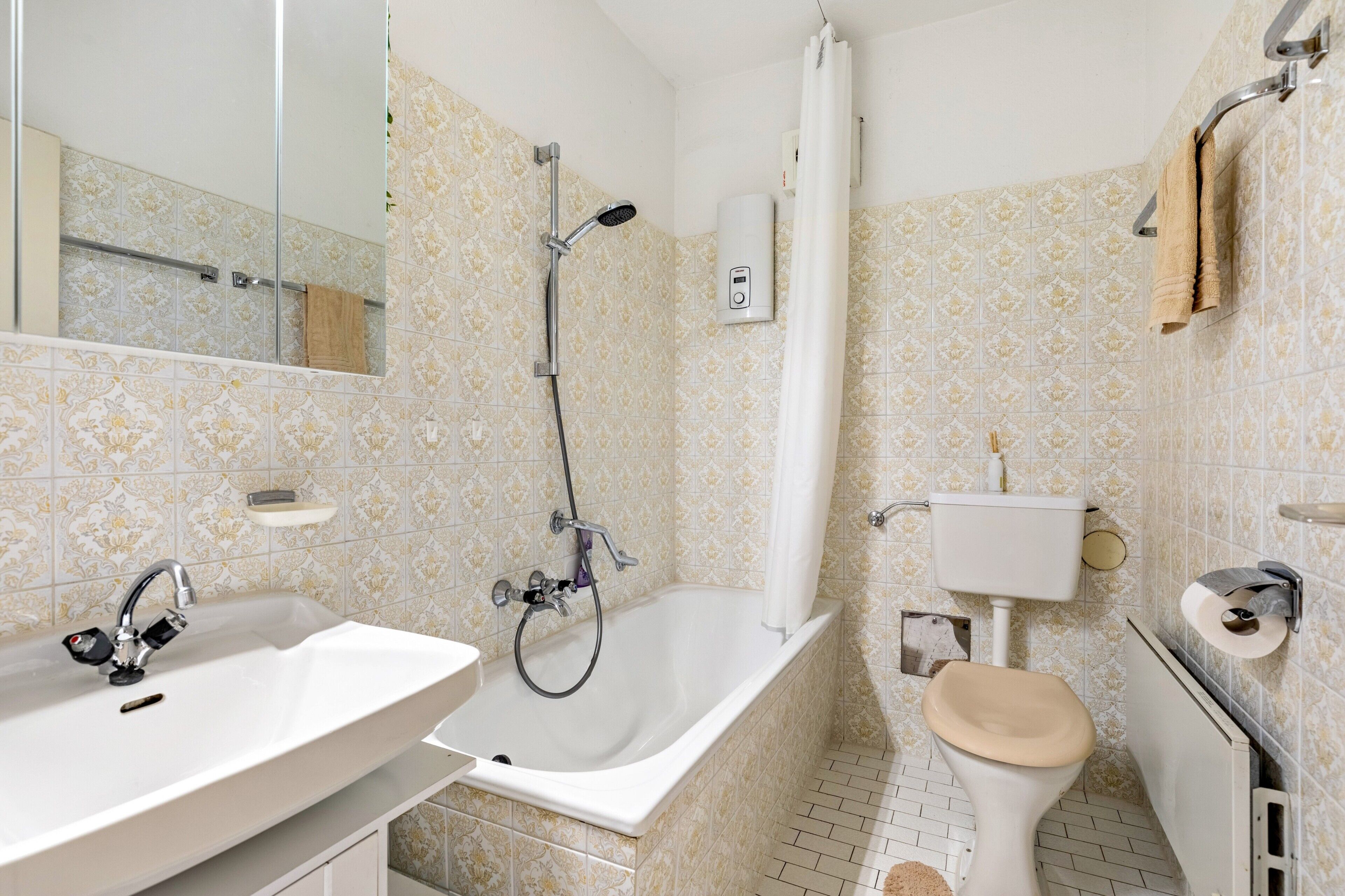 Une salle de bain équipée d’un lavabo, d’une baignoire, de toilettes et d’un miroir.