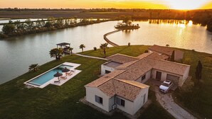 Ein Haus mit Pool, überdachter Terrasse und Blick auf einen Fluss.