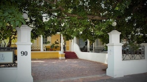 A building entrance with a number sign, a staircase, and a paved area. - Tintagel Guest House (Cape Town)