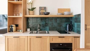 Eine moderne Küche mit Holzschränken, einer Spüle, einer Kaffeemaschine und einer Zimmerpflanze.