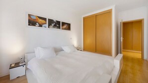 Una camera da letto con un letto, un comodino, un armadio e tre quadri appesi al muro.