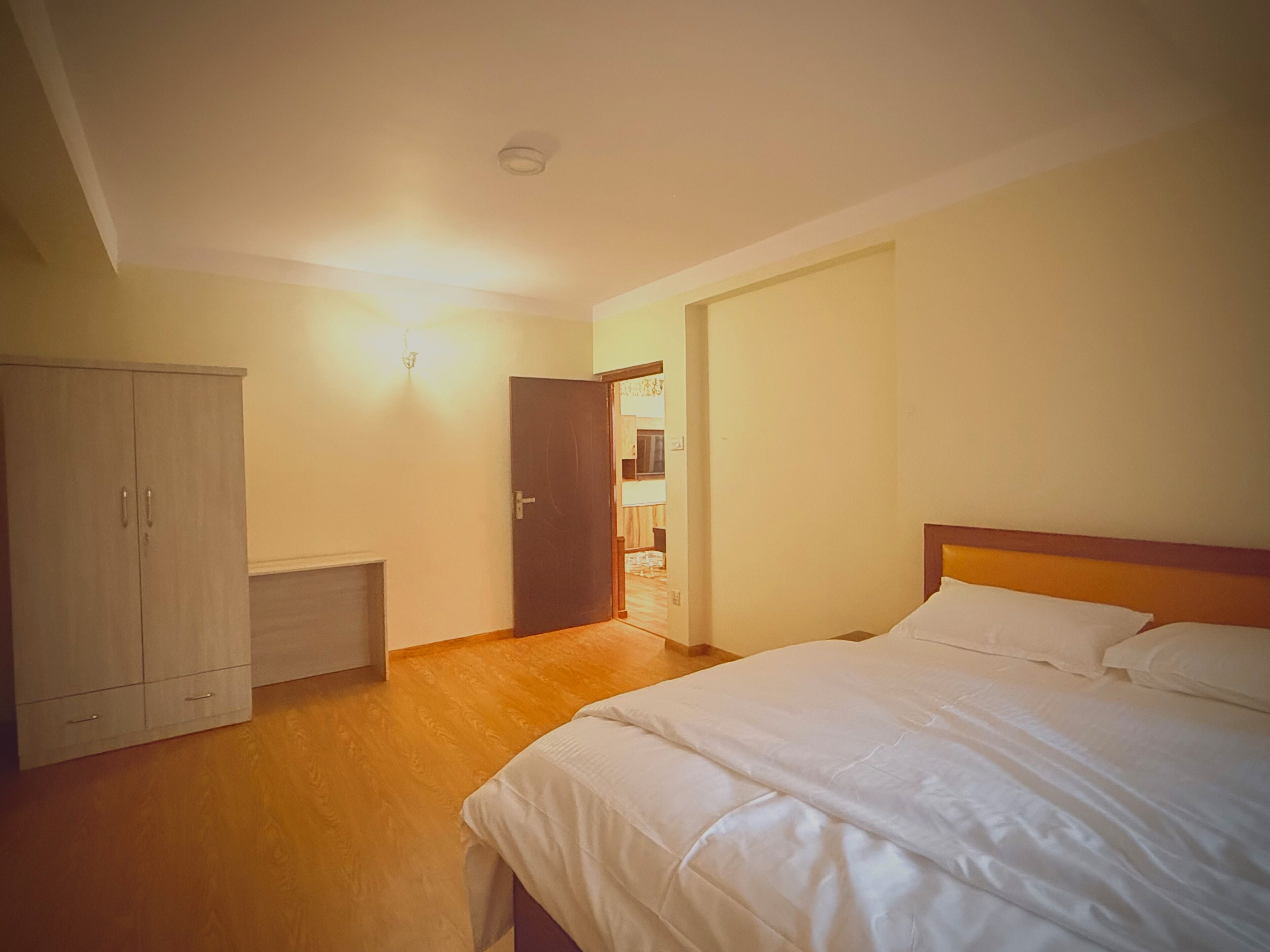 Un dormitorio con cama, armario y puerta que da a otra habitación.