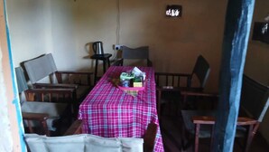 A small dining area with a table covered by a checkered tablecloth, surrounded by wooden chairs.