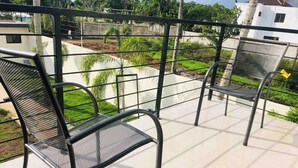A balcony with two metal chairs and a metal table, surrounded by a metal railing. - Serene 2-bedroom Apartment With Private Pool in Sabana de la Mar (Sabana de la Mar)