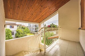 A balcony with a wooden ceiling, a metal railing, and a view of a residential area. - Casa Melita / Apartment with balcony Anina (Rovinj)