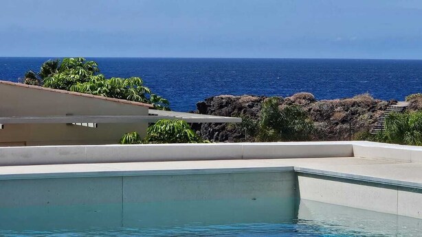 A swimming pool with a view of the ocean and rocky terrain. - VILLA SEA VIEWS V7 (Amarilla Golf)