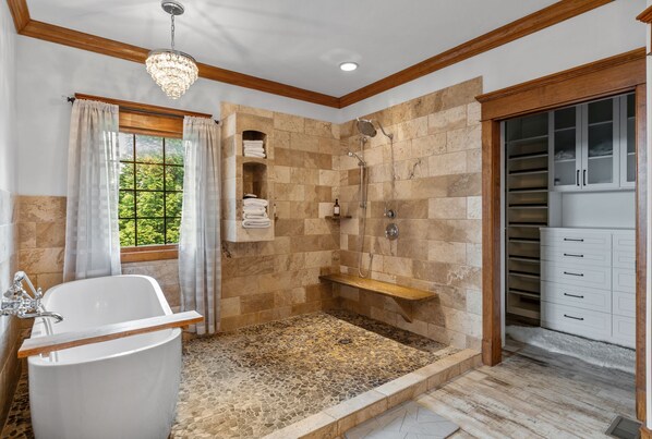 Une salle de bain avec une baignoire, une douche et un meuble-lavabo doté de tiroirs.