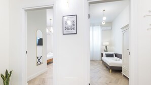 Moderni sisustus, jossa on sänky, yöpöytä, lamppu ja seinällä oleva kehystetty taideteos.