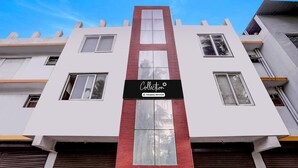 A modern building with a prominent 'Collection' sign, large windows, and a red accent strip.