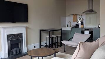 A living room with a fireplace, sofa, coffee table, and TV.