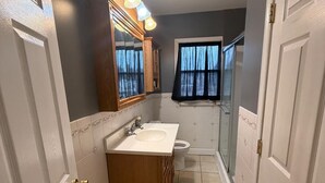 A bathroom with a vanity, sink, and mirror.