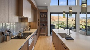 Une cuisine moderne avec des meubles en bois, une cuisinière encastrée et un grand îlot central doté d’un évier.