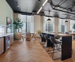 A modern kitchen with a bar area, wooden flooring, and large windows. - Spacious Downtown Miami Condo with Panoramic Views (Miami)