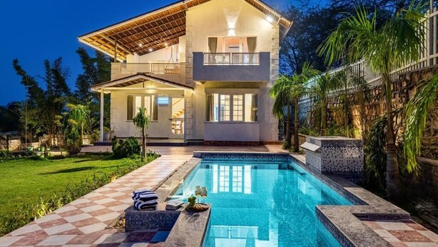 A two-story house with a swimming pool, a covered patio, and a well-maintained garden. - Alaya Stays Ramgarh Colonial 2BHK Villa (Jamwa Ramgarh)