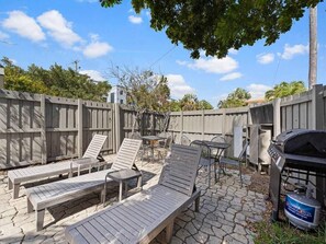 A patio with outdoor furniture, a grill, and a stone-tiled floor. - Cozy Haven Oasis: Pool| Los Olas |Wilton Manors (Wilton Manors)