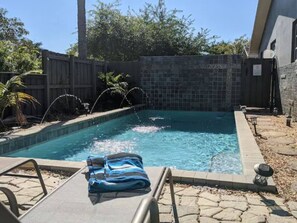 A swimming pool with a tiled edge, surrounded by a wooden fence and stone pathway. - Cozy Haven Oasis: Pool| Los Olas |Wilton Manors (Wilton Manors)