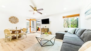 A modern living room with a sofa, coffee table, dining table, and chairs. - Amazing Location, Across from the Beach W/Jacuzzi! (San Diego)