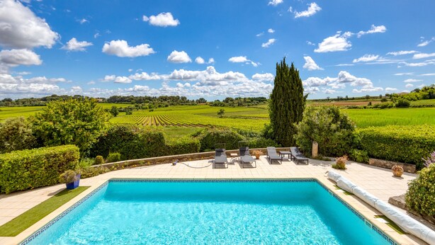 A swimming pool with lounge chairs and a view of a green landscape. - Languedoc Villa with Pool and Mountain View (Pailhès)