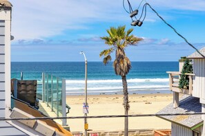 A beach view with a palm tree, a street lamp, and a clear sky. - Great Reviews, Large Rooftop Deck W/Parking, Stunning (San Diego)