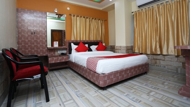 Une chambre d’hôtel équipée d’un lit, d’un bureau, d’une chaise et d’un appareil de climatisation.