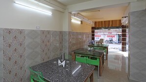 Un restaurant avec un comptoir, des chaises et un mur recouvert de carreaux.