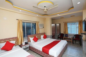 A hotel room with three beds, a ceiling fan, an air conditioning unit, and a television. - Collection O Kolkata Airport Road (Kolkata)